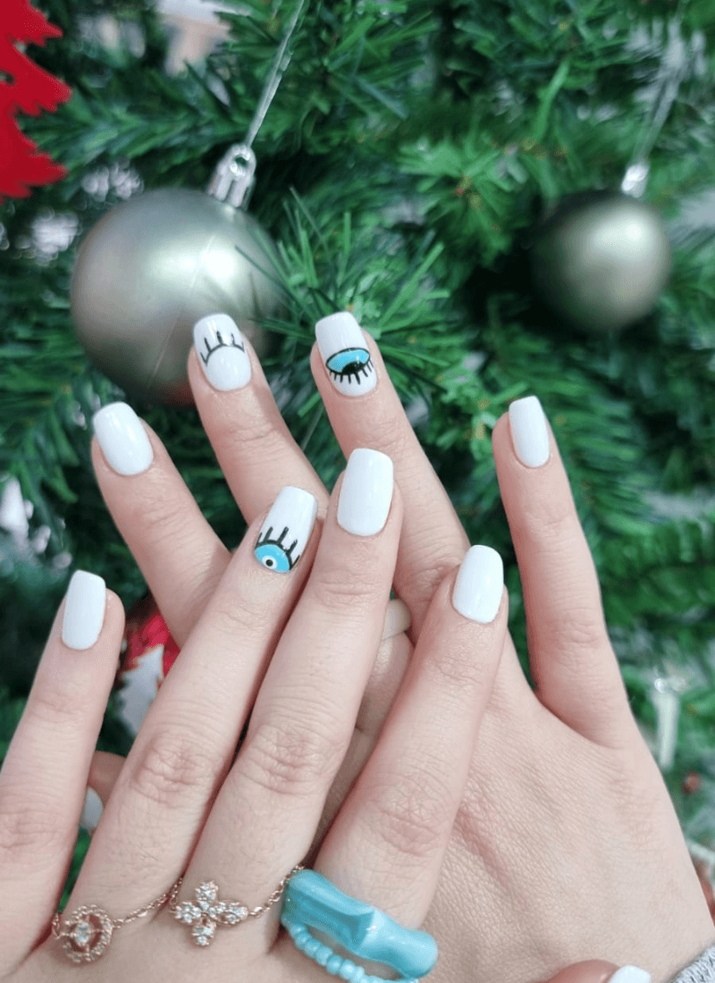 White manicure with blue eye nail art
