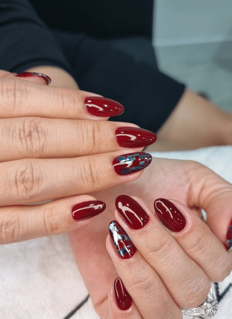 Deep red manicure with metallic accent nail art